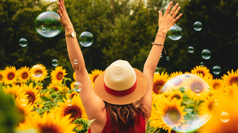 woman wearing hat in flower bed