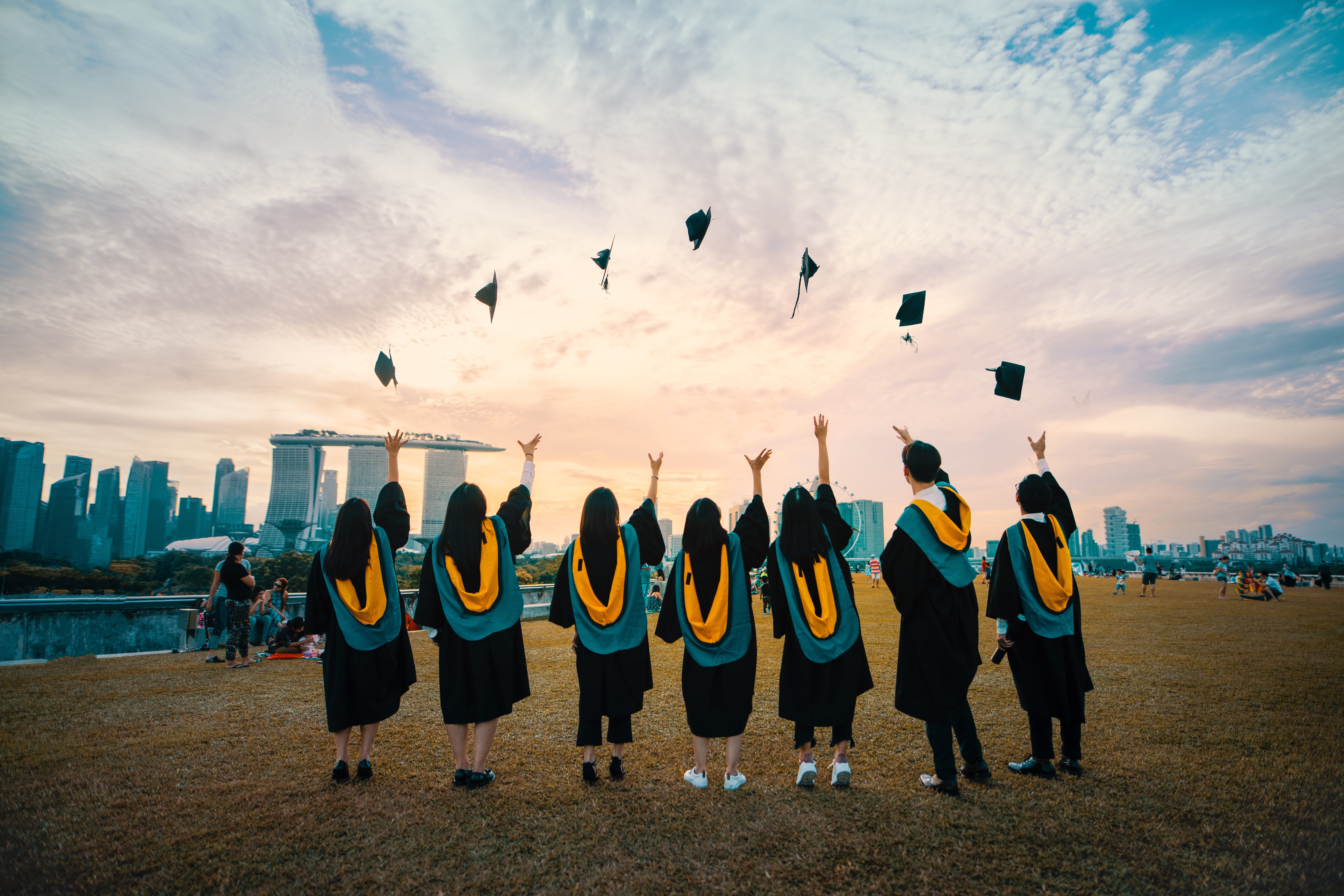 A group of graduates tossing their graduation hats into the air.