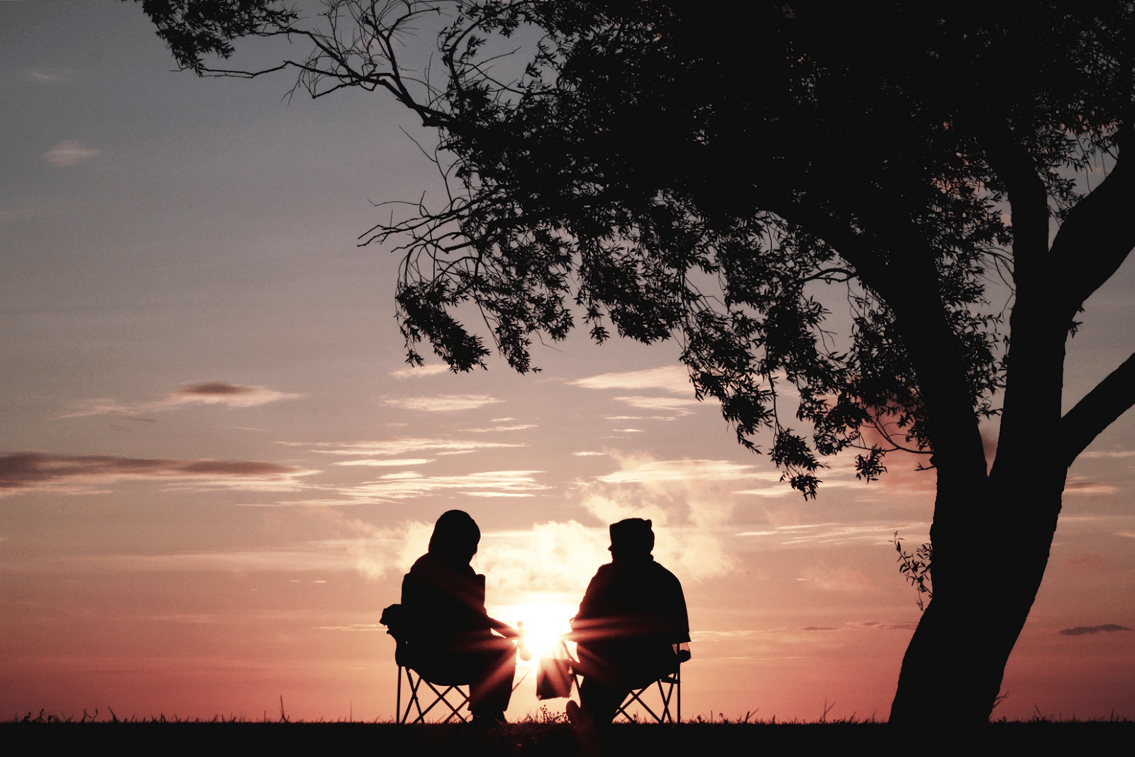 couple sitting in chairs watching sunset