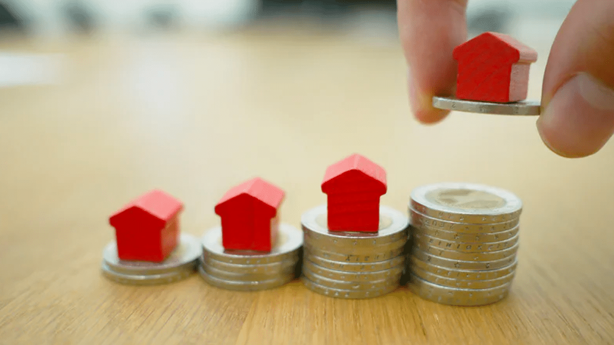 Setting up stacks of coins with tiny Monopoly game house pieces sitting on top.