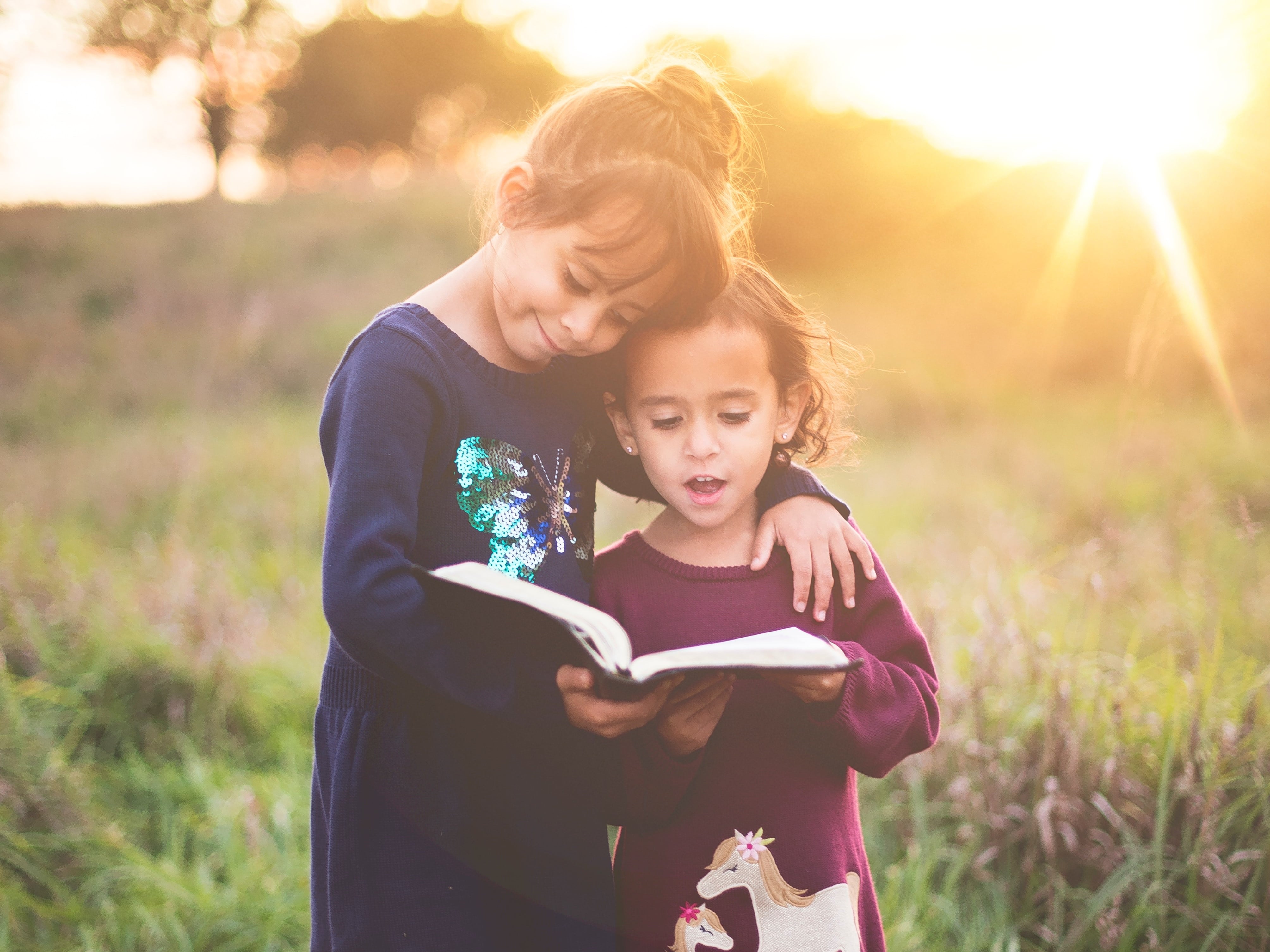 Two kids reading together.